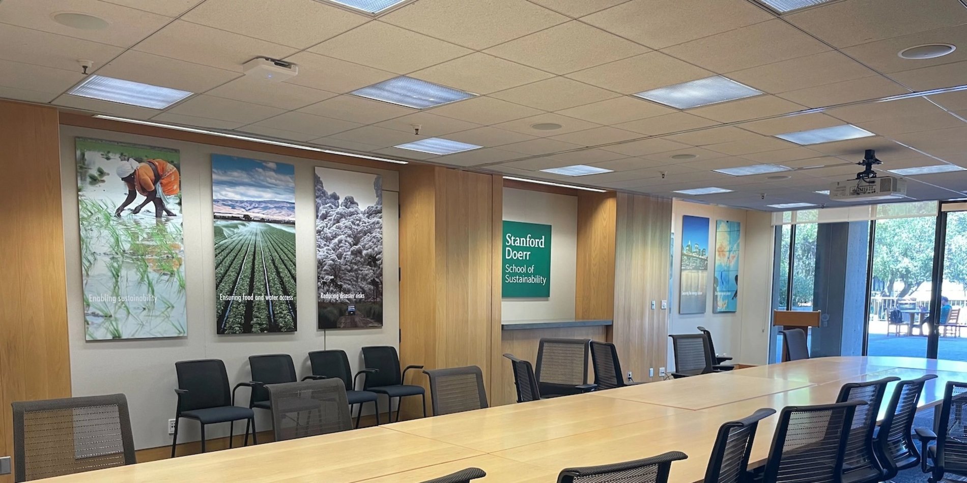 A conference room with artwork on one wall and an outdoor view.